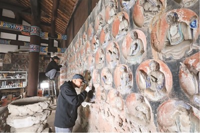 　2023年3月31日，大足石刻小佛灣修復(fù)現(xiàn)場，修復(fù)人員正在對石窟造像進(jìn)行清理。小佛灣石窟保護(hù)修復(fù)工程于2019年6月啟動(dòng)，目前已完成整個(gè)工程量的六成。  　　黃 舒攝（人民圖片）