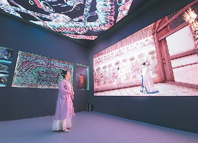 第十九屆中國（深圳）國際文化產(chǎn)業(yè)博覽交易會(huì)設(shè)立了“數(shù)字中國——AI時(shí)代的文化創(chuàng)新”主題展區(qū)。一批大數(shù)據(jù)、人工智能等技術(shù)應(yīng)用文化企業(yè)參展。數(shù)字化助力中華傳統(tǒng)文化“活”起來，也為現(xiàn)場(chǎng)觀眾帶來了新鮮的觀展體驗(yàn)。   圖為一名身著傳統(tǒng)服飾的觀眾在文博會(huì)甘肅展臺(tái)觀看數(shù)字敦煌展覽。   新華社記者 梁 旭攝