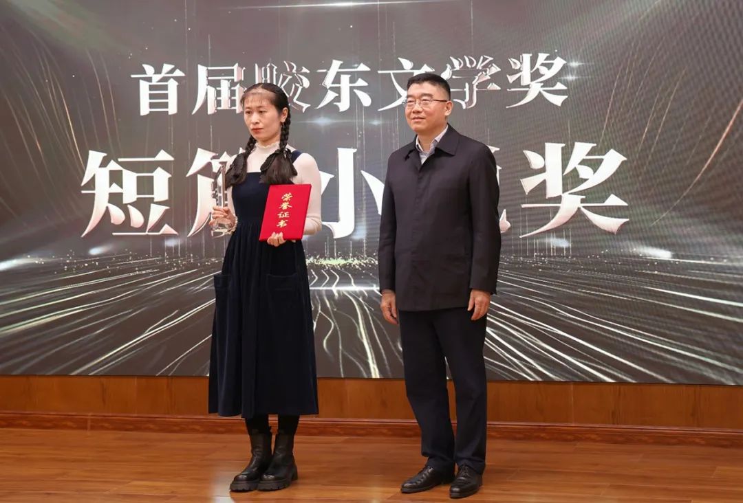 山東省作協(xié)黨組書記、副主席趙藝?。ㄓ乙唬? 為短篇小說獎獲得者王銘嬋頒獎