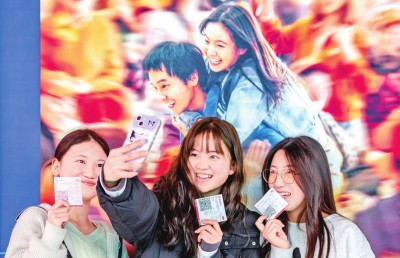 2月18日，觀眾在貴州省黔西市一家影院的電影海報前留影。 新華社發(fā)