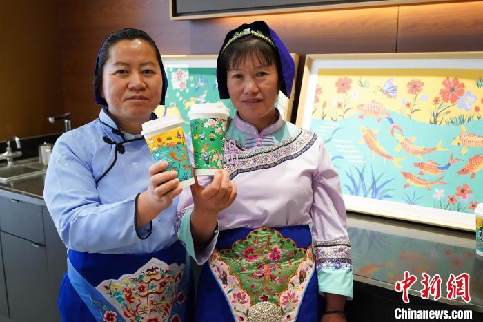 圖為農(nóng)民畫家展示她們被印在星巴克咖啡紙杯上的畫作。中新網(wǎng)記者劉冉陽 攝