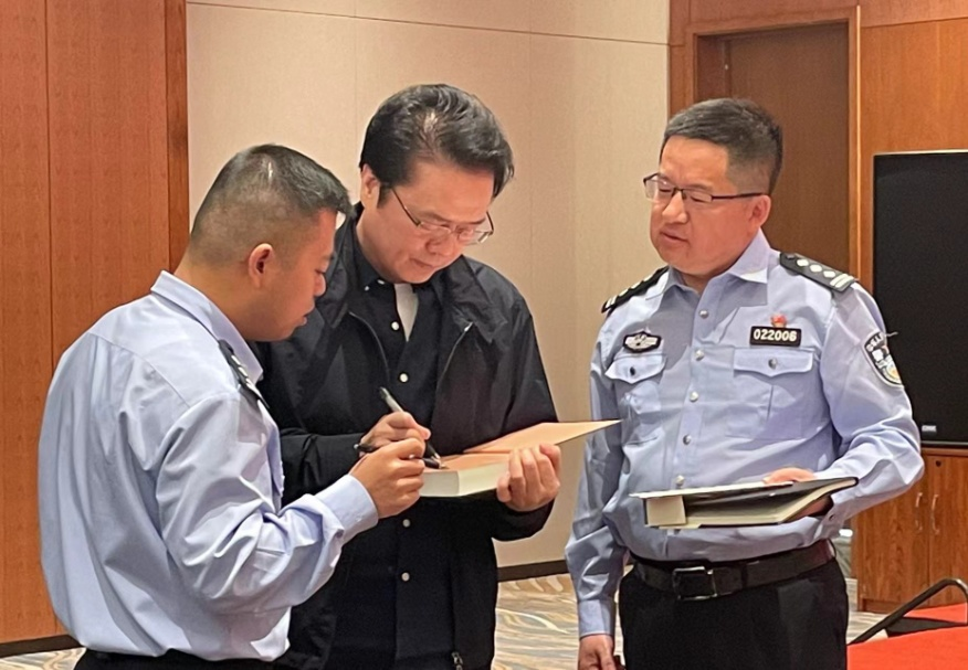 活動期間，陳彥（圖中）在給警營作家簽名。