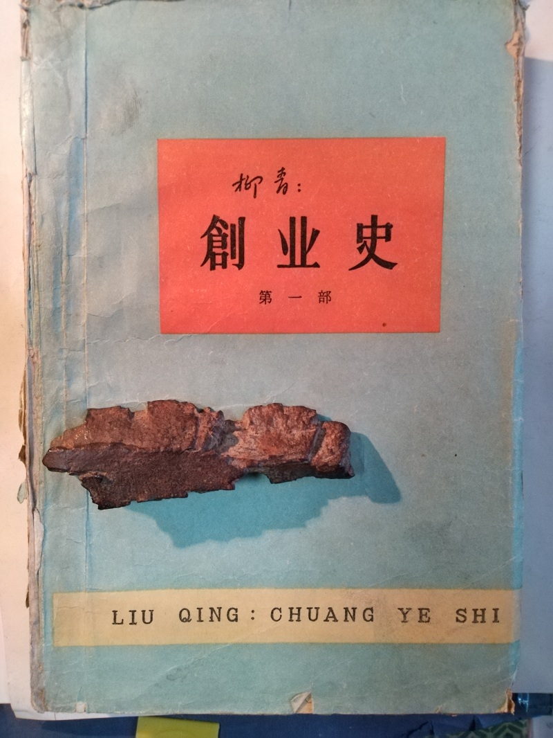 長篇小說《創(chuàng)業(yè)史》(第一部)書影與柳青曾收藏的彈片。 (文金 攝)