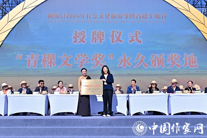 陳亞軍主編代表《民族文學(xué)》向阿壩縣授牌，紅梅部長(zhǎng)接牌。