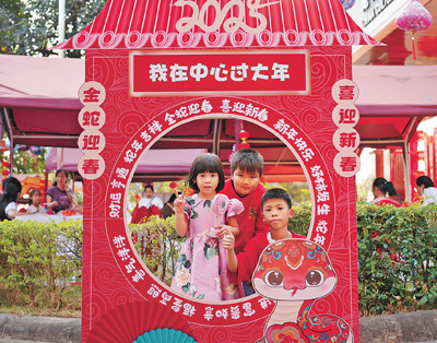 老撾民眾在“歡樂春節(jié)”廟會(huì)現(xiàn)場(chǎng)設(shè)立的新春祈福打卡點(diǎn)拍照。  坎帕頌攝