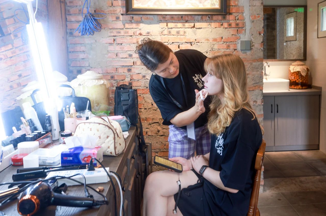 2025年6月30日，百集微短劇《鐘鼓樓前》在北京鼓樓前開機(jī)。圖為俄羅斯籍女演員瑪利亞在開拍前化妝。 中新社記者 賈天勇 攝