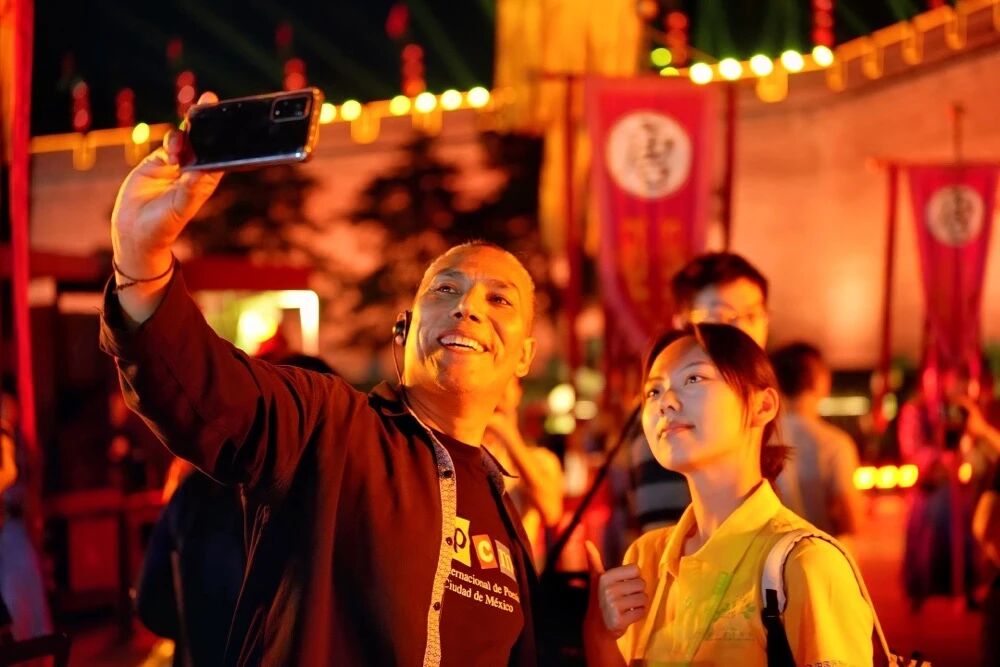 參加2025國(guó)際青春詩(shī)會(huì)的拉美詩(shī)人和中國(guó)詩(shī)人在西安永寧門(mén)觀看歡迎儀式。圖為墨西哥詩(shī)人馬努艾爾·夸烏特勒在歡迎儀式后與志愿者合影