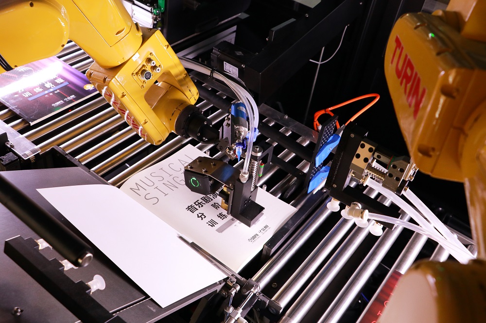 六軸工業(yè)機(jī)器人精細(xì)配合，完成圖書(shū)各項(xiàng)加工作業(yè)。 廣東省立中山圖書(shū)館供圖